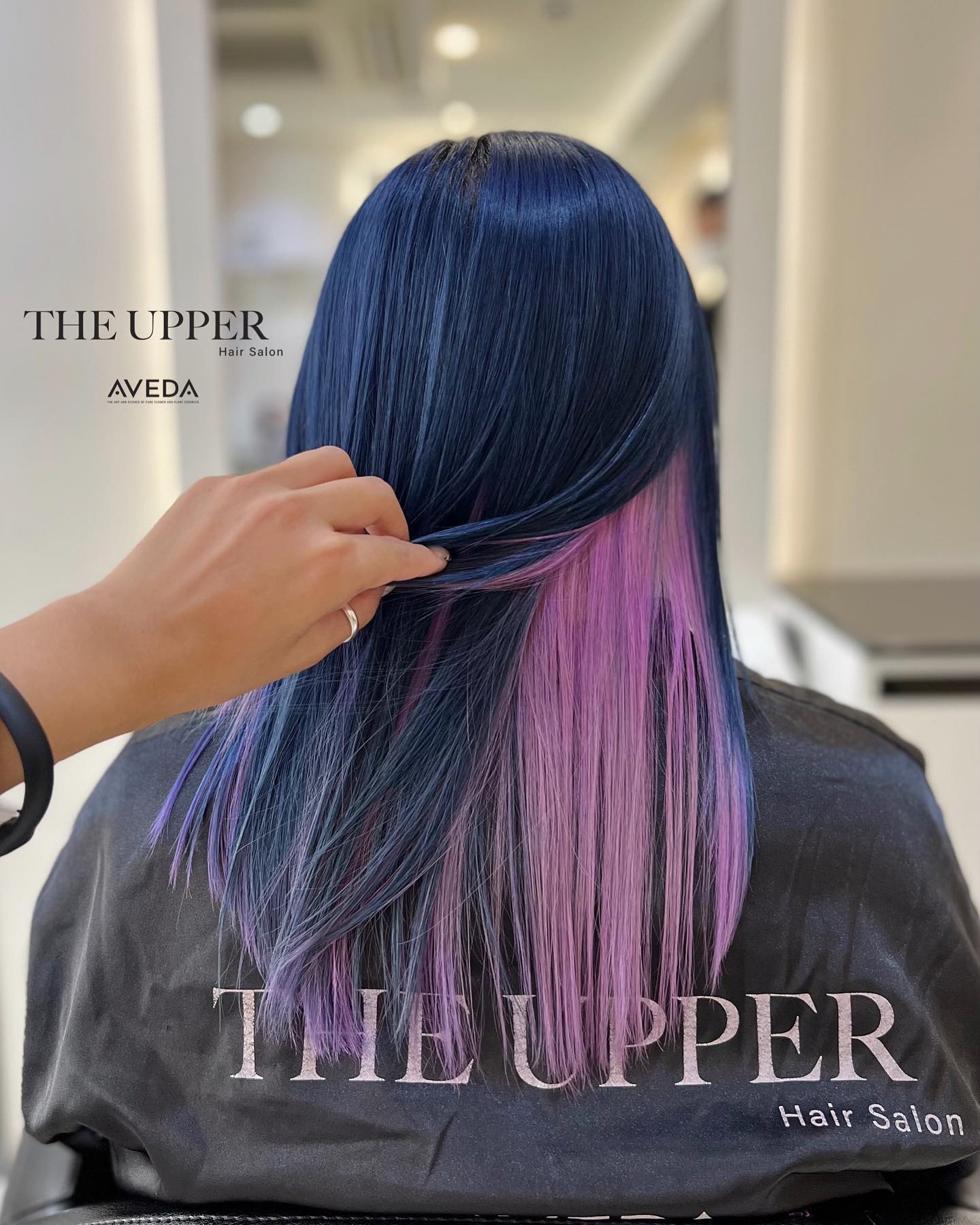 Lavender-toned wavy bob tucked behind the ear